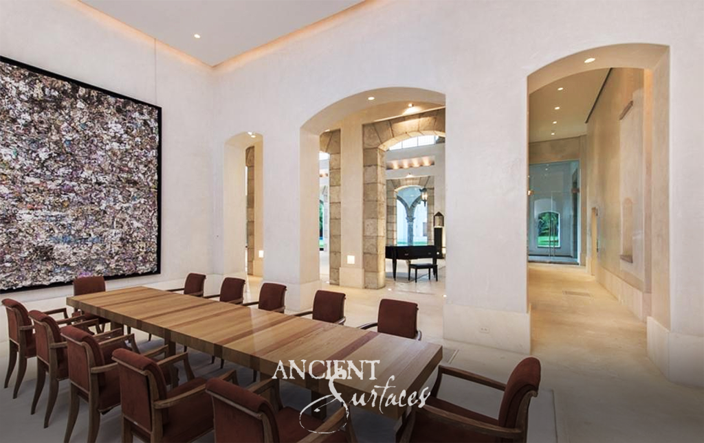 Main hall where tall arched openings are framed in massive reclaimed limestone blocks, leading through to a colonnade of antique stone columns
